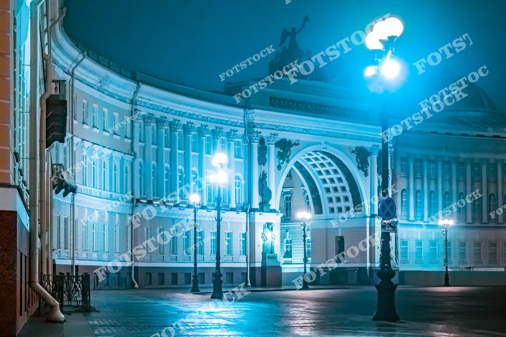 На фотографии изображена арка Главного штаба, подсвеченная холодным голубым светом, который подчеркивает ее изящные архитектурные линии. Ночная атмосфера и отсутствие людей создают чувство спокойствия и уединения. Величественная арка, расположенная на Дворцовой площади, является одним из ключевых символов Санкт-Петербурга. Ее классический стиль идеально гармонирует с окружающей исторической застройкой.